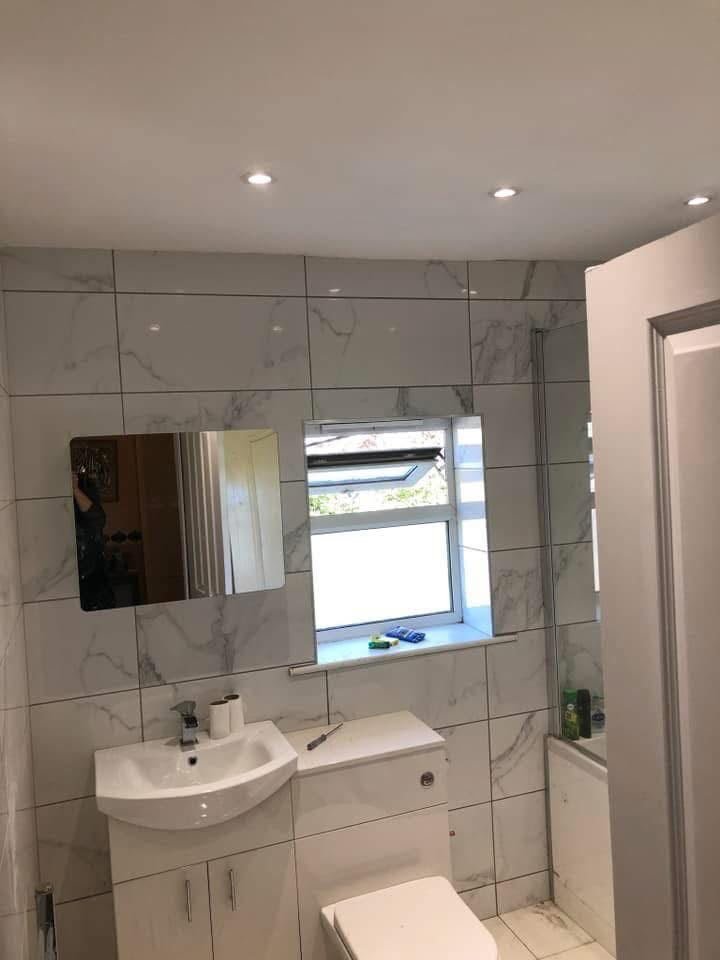 Marble-effect tiled bathroom with new vanity unit and spotlights