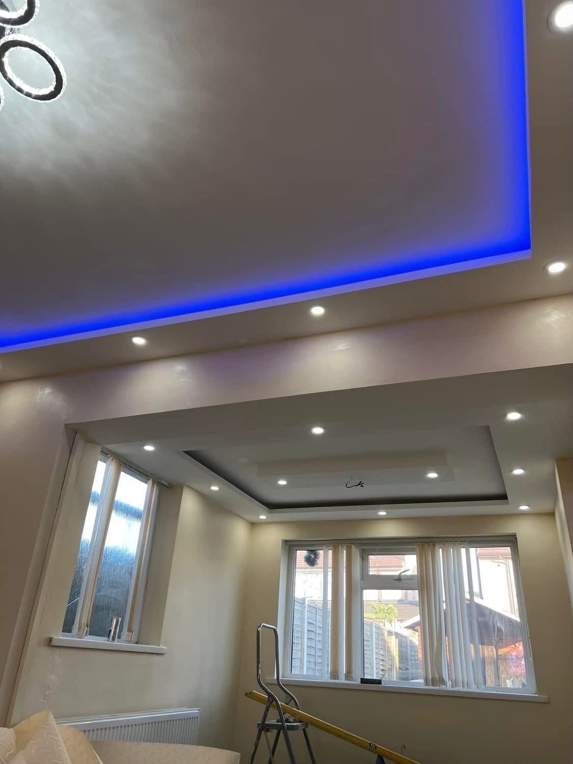 Drop ceiling with recessed spotlights and blue LED cove lighting